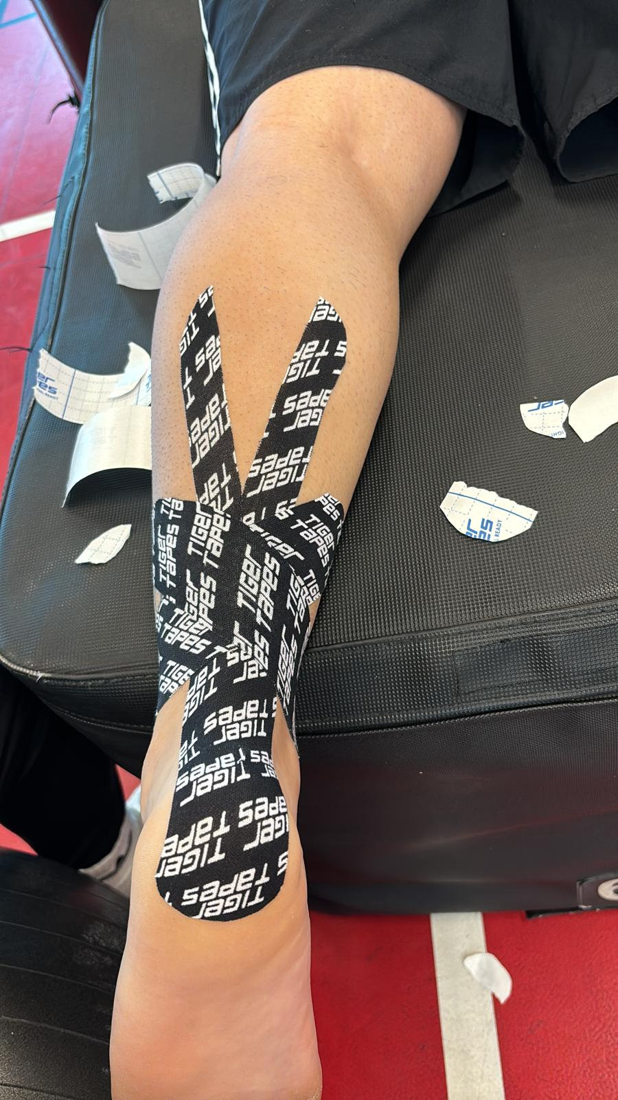 Close-up of kinesiology tape applied along a calf and shin